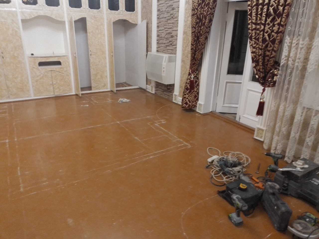 The house before work began — old floors, built-in cabinets and the first tools arriving
