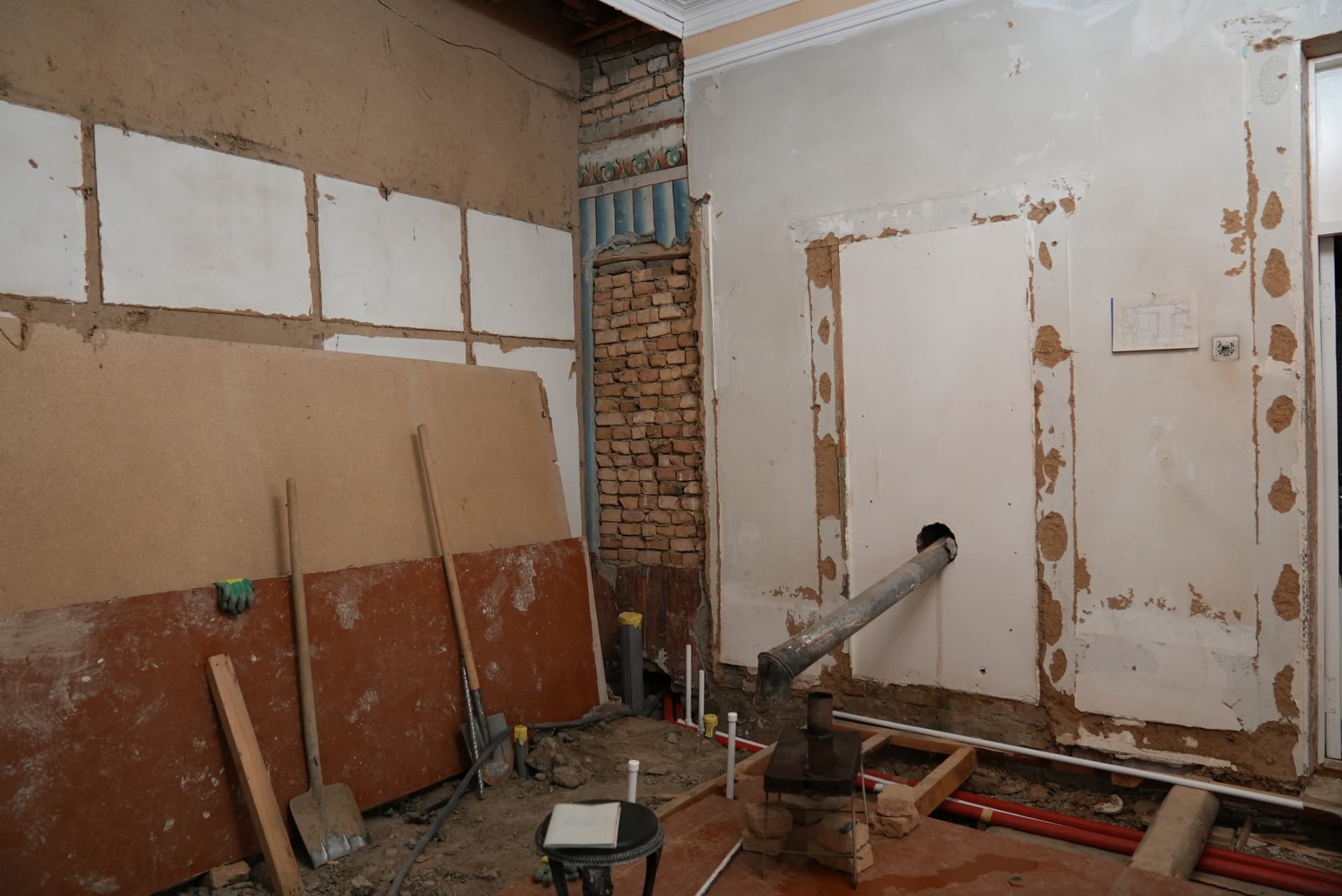 Walls opened to the original brick, with new plumbing being laid